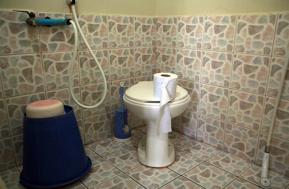 Toilette mit Klopapierrolle auf dem Deckel, gut bei Durchfall