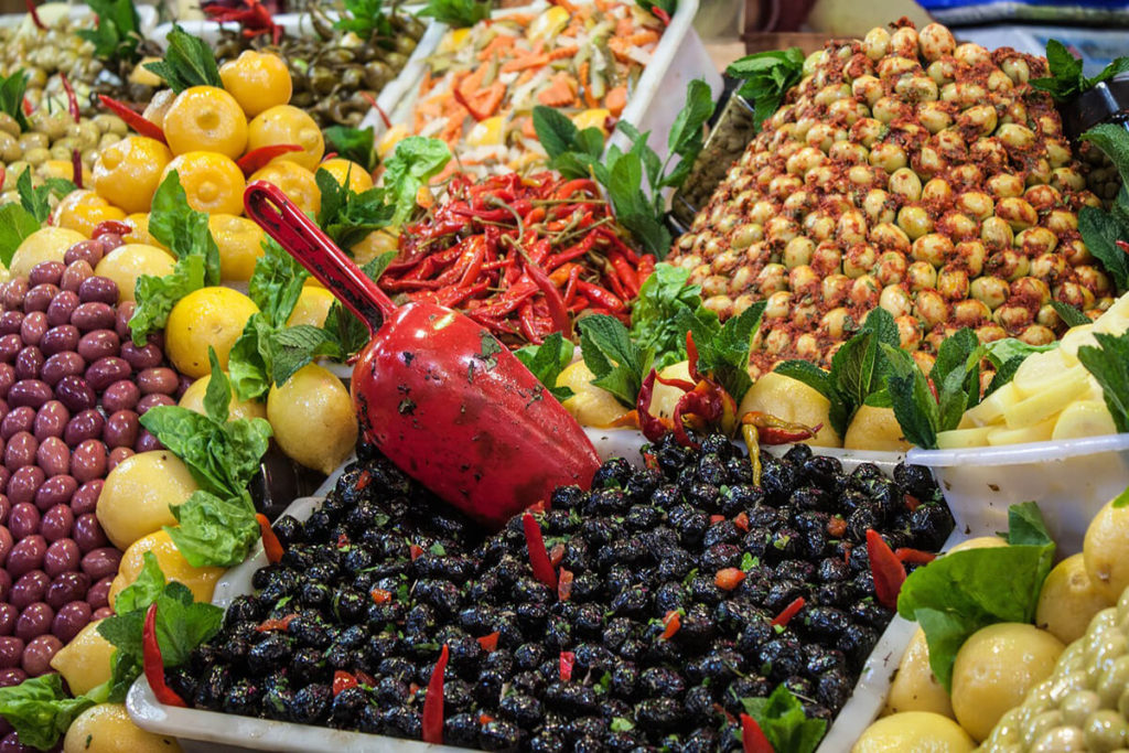 Oliven und eingelegte Zitronen an einem Marktstand beim Einkauf für die marokkanische Küche